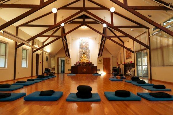 The Main Dharma room of the Providence Zen Center: There are blue square cushions with smaller round cushions on top of each one.