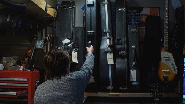 Hudson sorting through instrument cases.