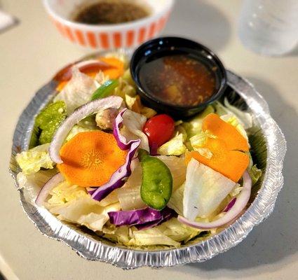 The side salad that comes with an entree. It has Italian dressing in a small cup.