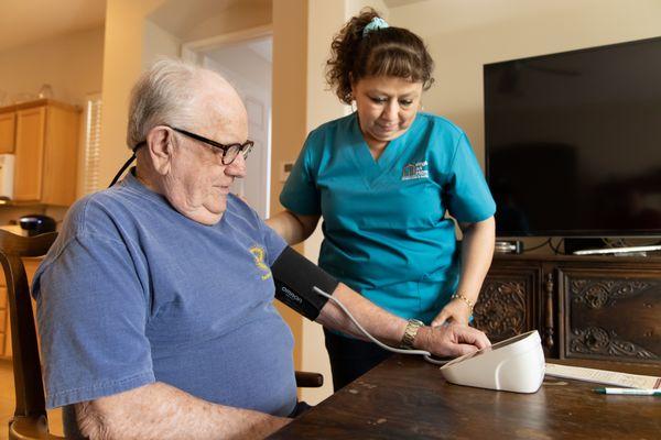 Caregiver checking clients blood pressure