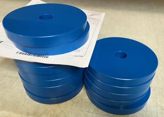 Blue HDPE discs with center hole, used in food processing.