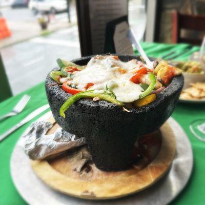 Molcajete loaded with grilled veggies plus sautéed shrimp, topped with melted cheese. Delicious!