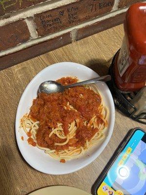 Pasta & Meatballs kids portion. Meatball already cut up on the little girls plate.