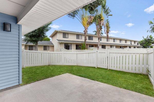 back yard with small covered patio and green grass