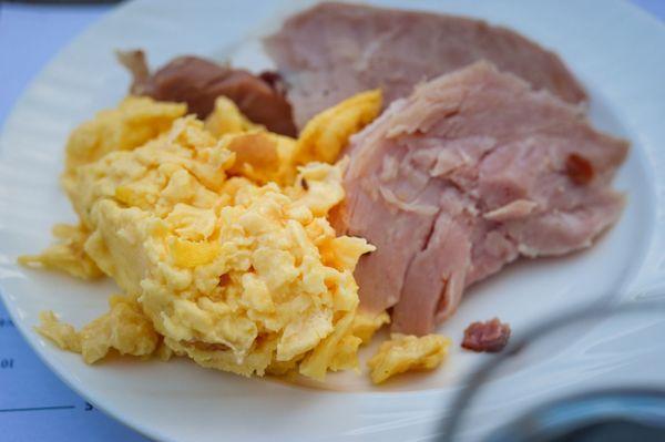 over cooked soggy eggs and ham from carving Station