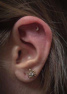 Helix piercing done by Liz Gore with a hammered moon in 14k gold from Junipurr