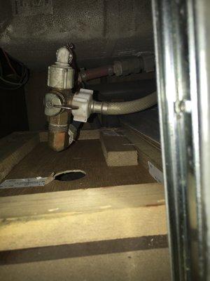 Valve behind paneling and below nightstand drawer