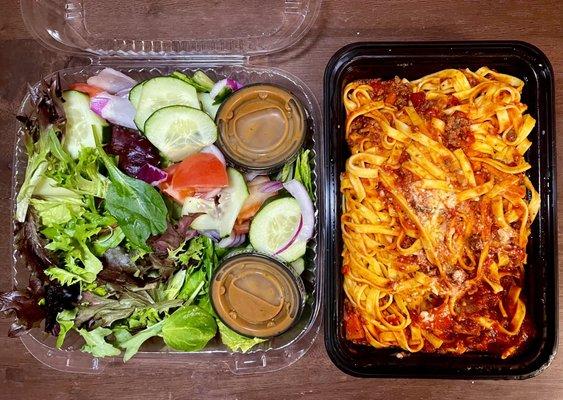 Mixed green salad on left, pasta bolognese on right