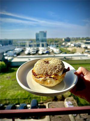 Bacon egg and cheese Sandwich on a sesame bagel with green onion and cheddar cream cheese