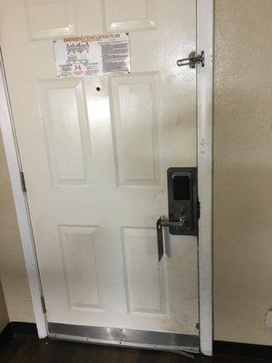 This the dirty chipped and 1/4 inch see-through door gap with Best Western emergency escape information.