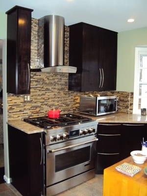 This is cherry wood with and espresso stain on Amesbury shaker style doors. Added trash can pull-out, spice drawer and pull-out shelves.