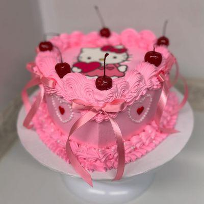 heart shaped birthday cake. edible hello kitty image, to decorate we used cherries, edible pearls and ribbon