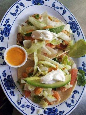 Shrimp tacos made with hand made tortillas, shrimp, lettuce, avocados, tomatoes, onion and cilantro.