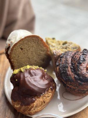 counter clock wise: Chocolate pistachio cream puff, poppy seed & chocolate babka, pistachio lemon tart, & olive oil earl grey cake