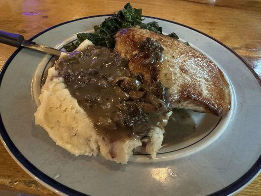 Seared pork chop with mashed potatoes and mushroom gravy. Spicy kale veggies.