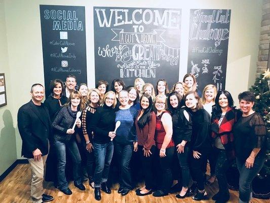 The staff gathered together for a photo after a cooking competition at A Cut Above Catering. What a fun holiday party!