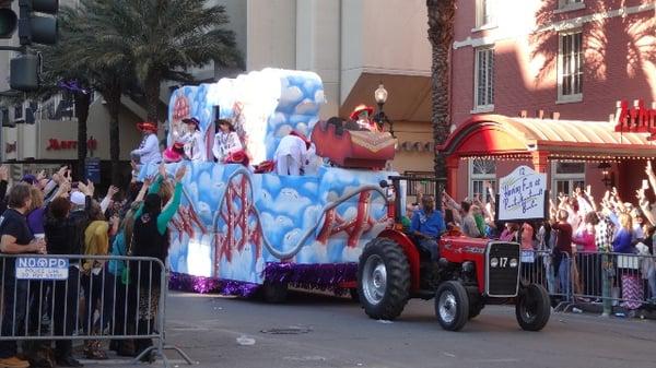 Floats with people reaching for beads