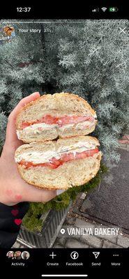 Sesame seed bagel with veggie cream cheese and tomato