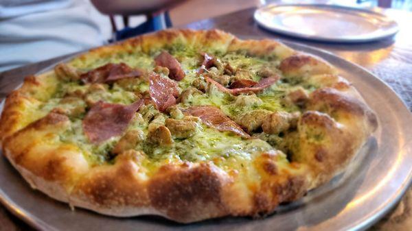 Custom personal pizza: salami and sausage with pesto sauce