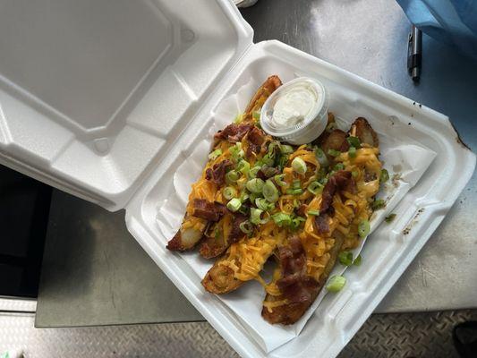 Loaded Potatoes skins Seasoned to perfection and topped with shredded cheddar cheese and bacon bits and green onions.and side of sour cream