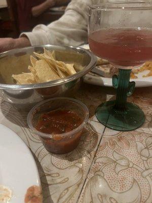 Salsa, small bag of chips dumped in metal pet bowl and a $10 very small margarita .