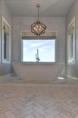 Master bathroom design and installation- marble herringbone floors, brick set on tub platform, marble mosaic on tub accent wall & backsplash