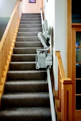 A stair lift folded up to show how much room is available on the stair case.