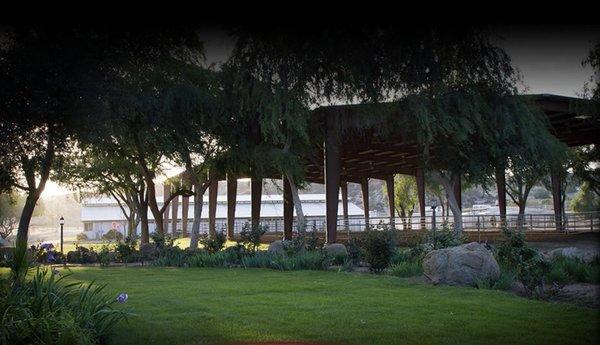 Indoor riding arena and grass area, indoor box stall barn in the background