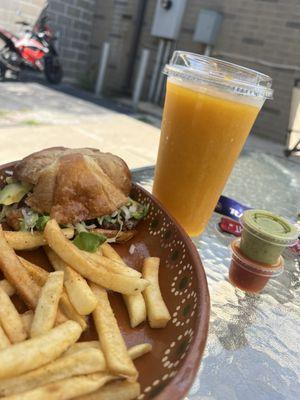 Steak Torta on a croissant. With a peach smoothie.