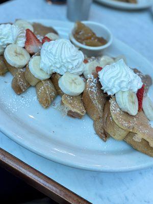 Fruity French Toast: Topped with powdered sugar, bananas, strawberries, and whipped cream. Apple compote on the side.