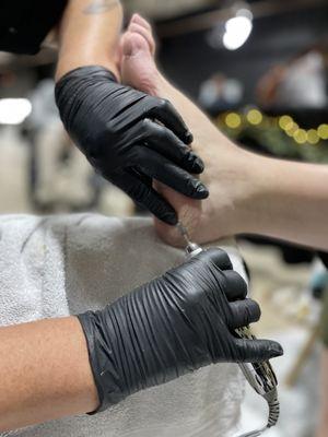 Heel cracks being removed during a Wellness Pedicure