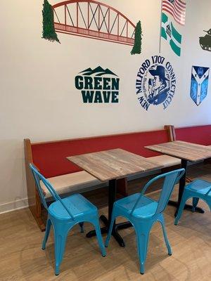 Interior seating area with mural of logos associated with New Milford