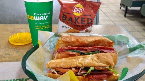 Italian BMT meal. white bread provolone cheese toasted add cucumber tomato black pepper spicy mustard vinegar and oil. barbecue baked Lay's