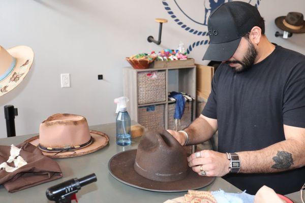 Taking the time to burn details into a customer's hat to create the perfect Nashville cowboy style hat.