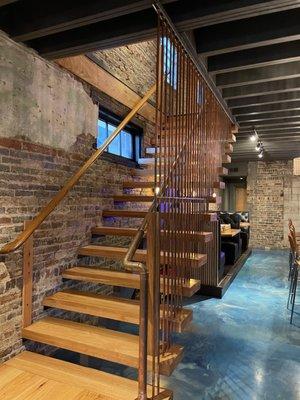 Obsessed with this custom stairway heading to the upstairs seating/bar