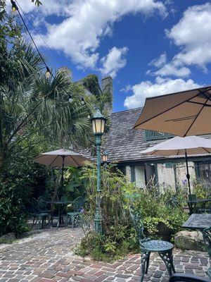 Garden patio with shade, tables and chairs.