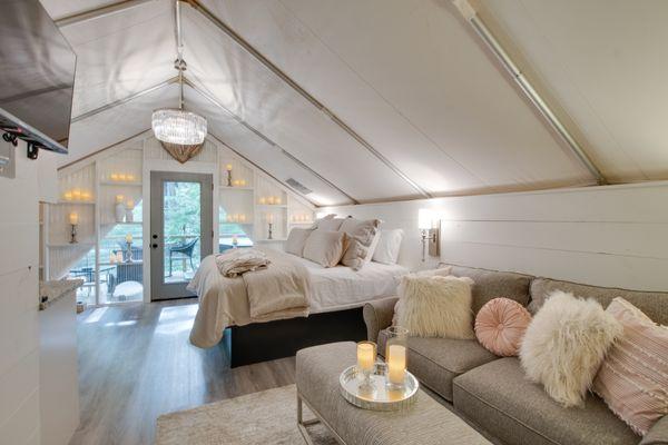 The inside of one of six on-site climage controlled glamping tents featuring private bath, kitchenette and deck.