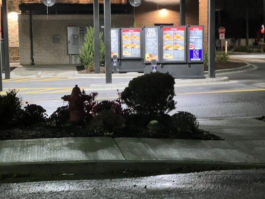 Drive-through area, which has two lanes, and is controlled by an employee using a headset talking to inside to relieve congestion.