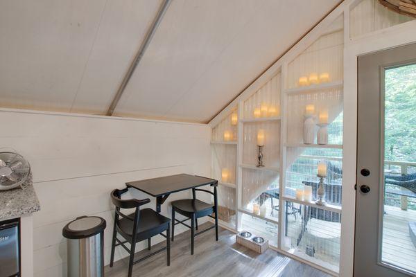 The inside of one of six on-site climage controlled glamping tents featuring private bath, kitchenette and deck.