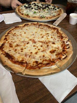 The cheese pizza with a friends supreme pizza in the background