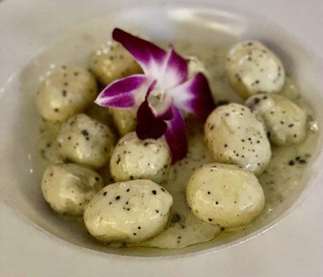 Gnocchi In A Truffle Cream Sauce Hand rolled stuffed potato dumpling, tossed with basil pesto and a truffle cream sauce.