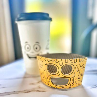 Coffee cup has faces printed all around it with a fun die cut sleeve.