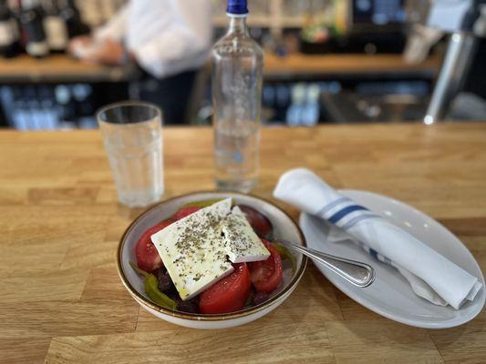 Greek Salad. Tomatoes, Cucumber, Red Onions, Olives and Peppers with oil & vinegar topped with feta & herbs.