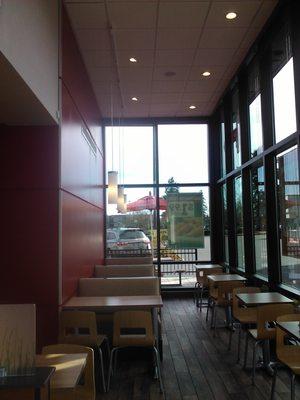 Here is a nice area to sit with some tall ceilings.  Behind that red wall is a fireplace with some plump chairs.