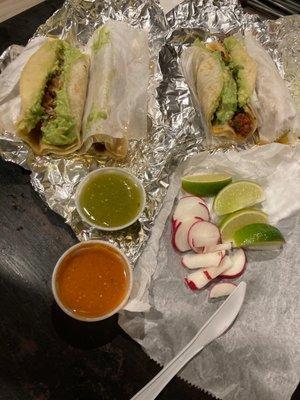 Churizo and carnitas tacos with guacamole red and green sauce on the side