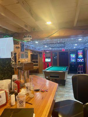 Seated at the end of the bar looking into the pool table room