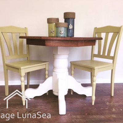 Solid oak pedestal table with coordinating chairs. Hurricane glass lanterns also available