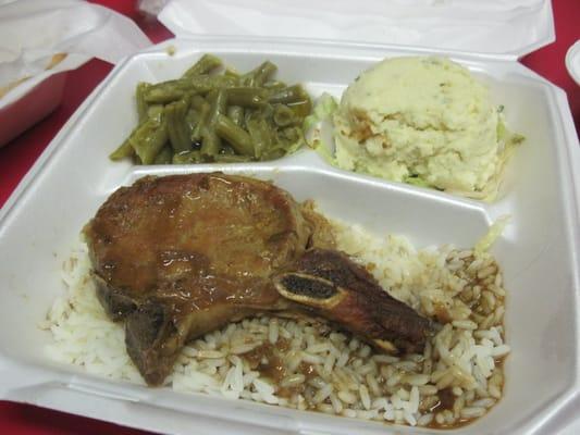 Smothered pork chop, rice and gravy, veggies and potato salad