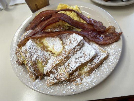 French toast breakfast with scrambled eggs and bacon.