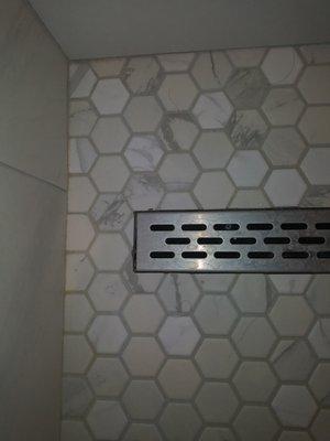 Chipped tile around linear drain